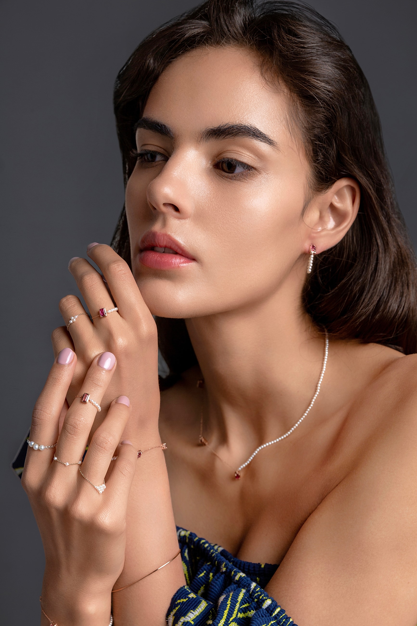 Jewelry model showcasing elegant rings and necklace.